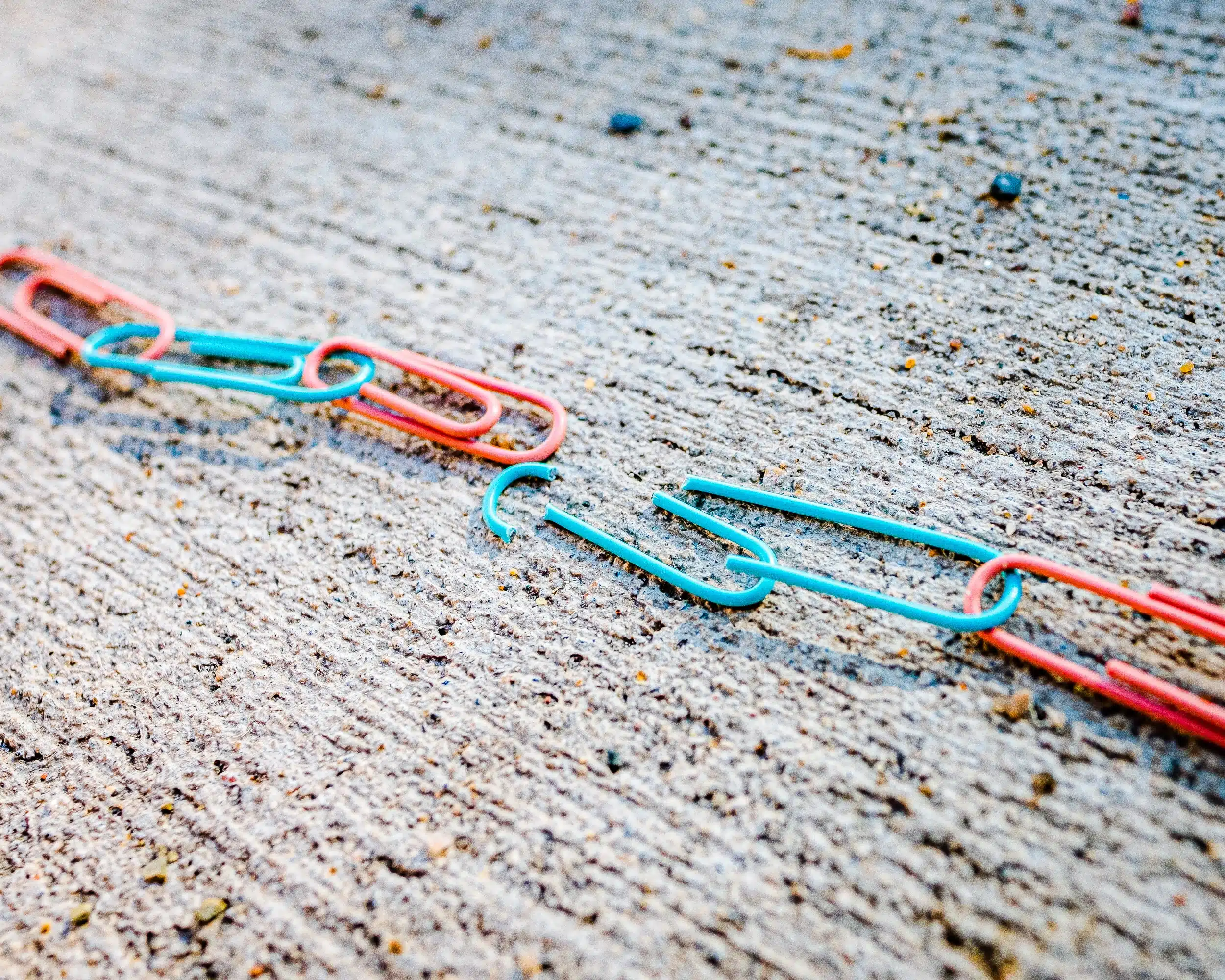 blue green and red plastic clothes pin linked together to symbol unity